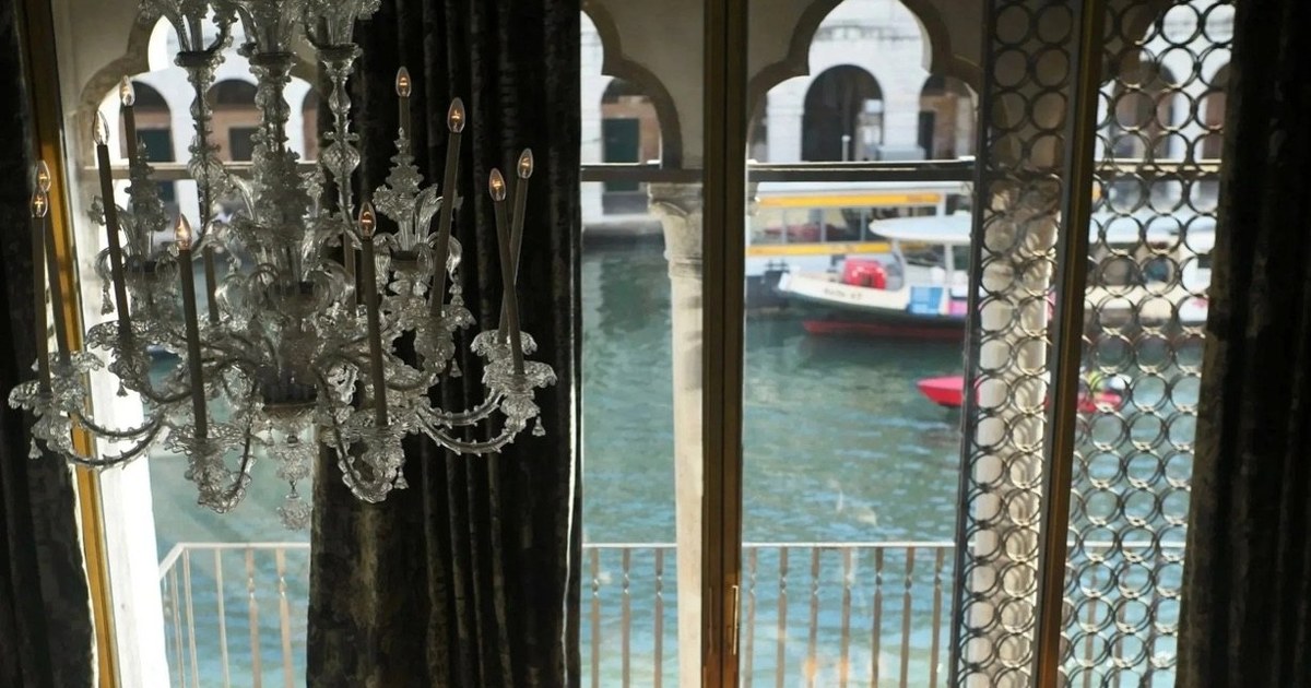 A Murano chandelier and Venetian gothic windows over the Grand Canal in a suite at the Venice Venice Hotel