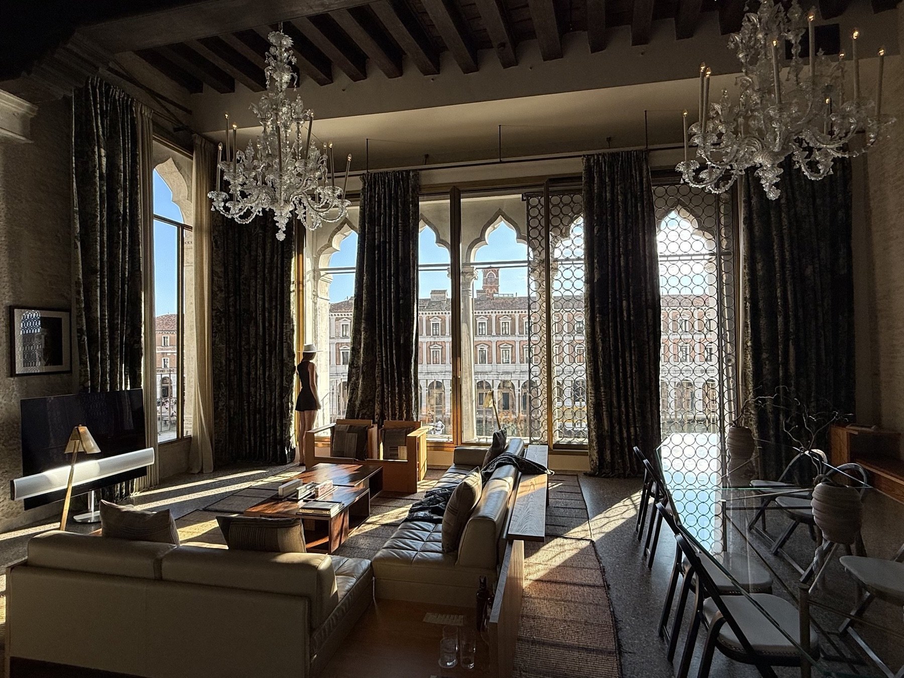 A Murano chandelier and Venetian gothic windows over the Grand Canal in a suite at the Venice Venice Hotel