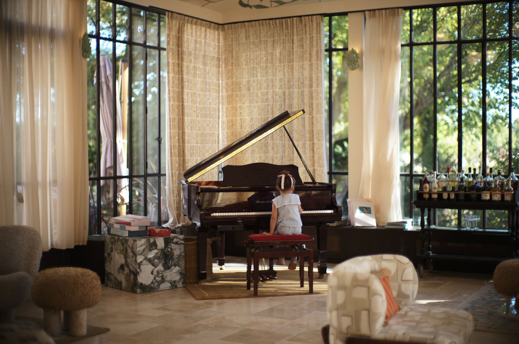 The glasshouse salon at Verneuil la douce, a grand piano under the iron and glass roof